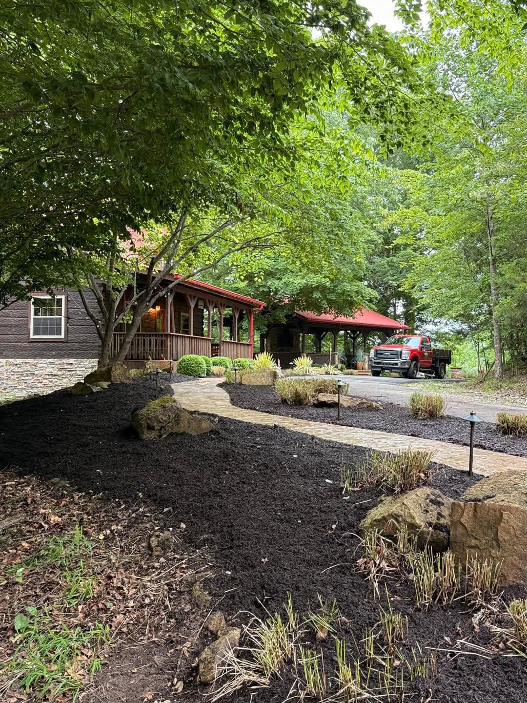 Luxury outdoor patio with stone pillars, wooden beams, string lights, and comfortable seating